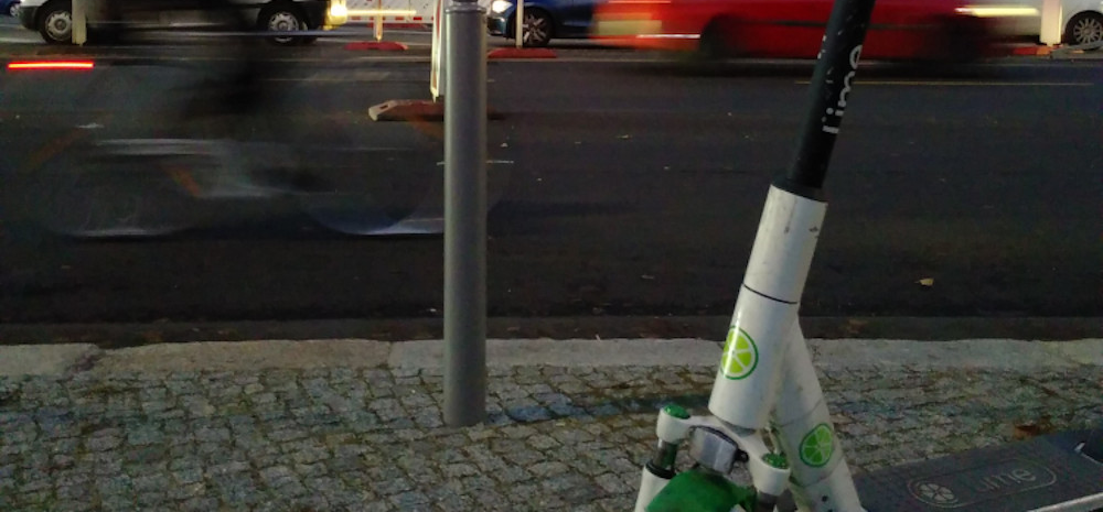 E-Scooter - ein Bildausschnitt einer Hauptstraße und eines E-Scooter-Teils